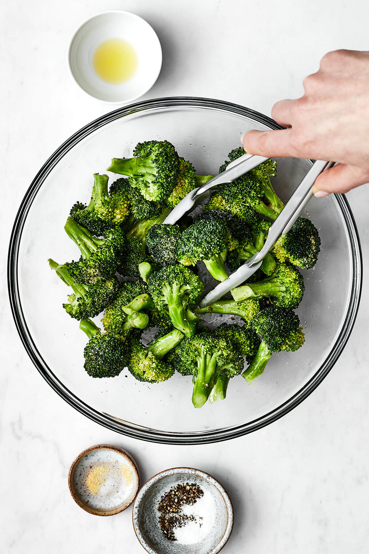 Tossing broccoli in seasoning before air frying