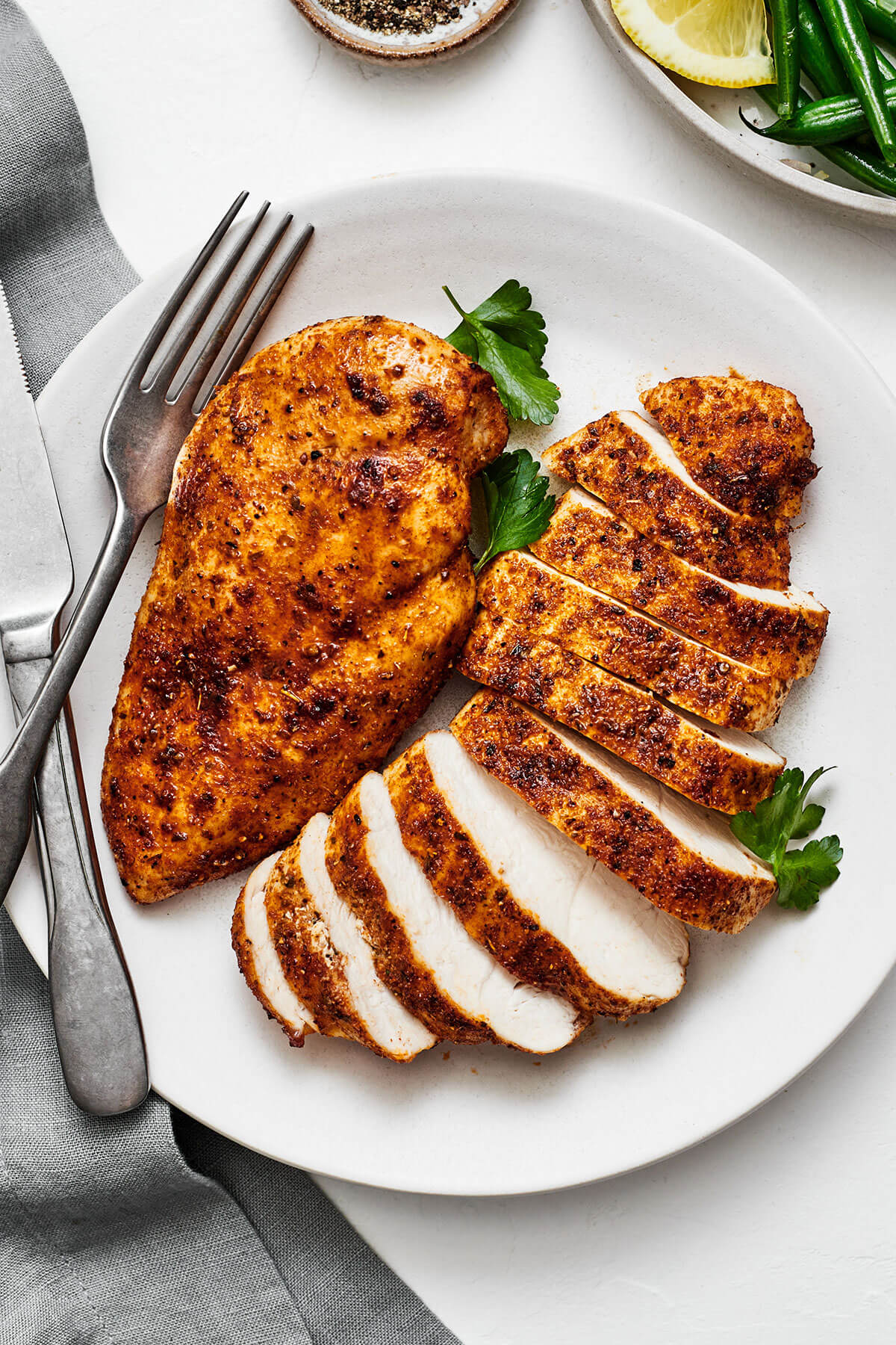 Air fryer chicken breasts on a plate with a fork