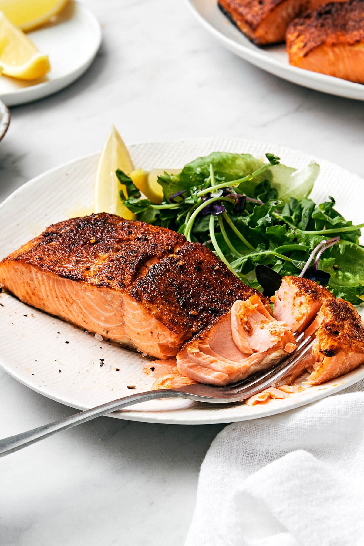 Air fryer salmon on a plate with a fork.