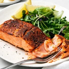 A plate of air fryer salmon and leafy greens.