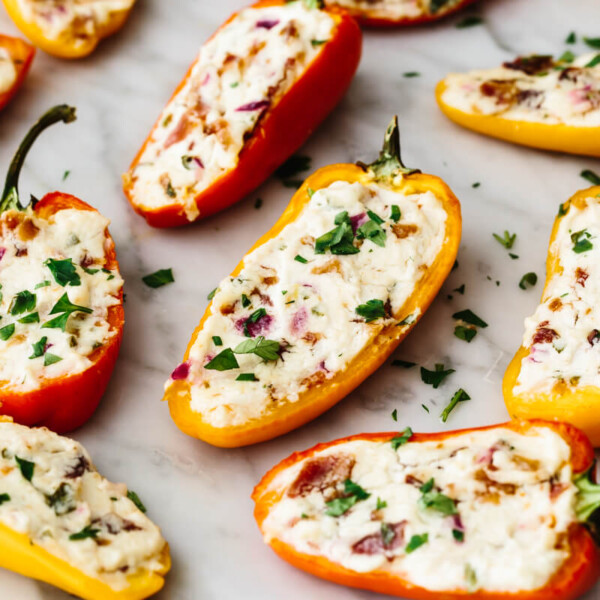Bacon goat cheese stuffed mini peppers on a table with parsley.
