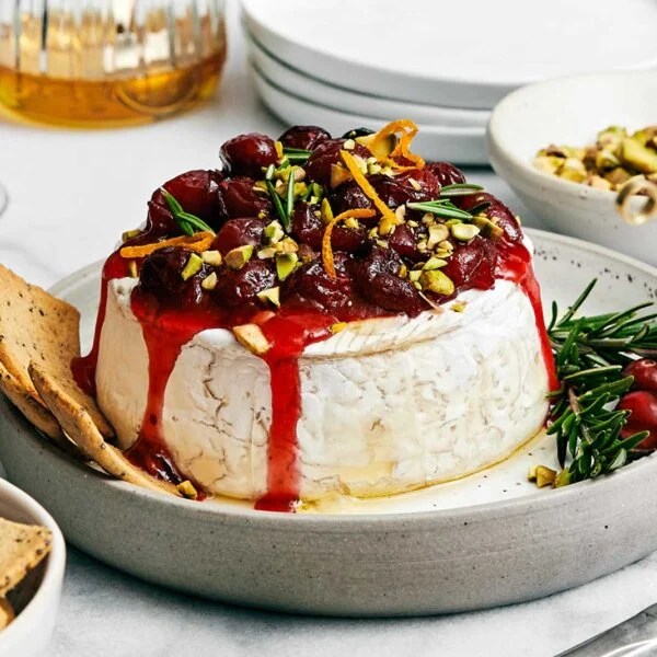 A plate of baked brie with cranberry sauce.