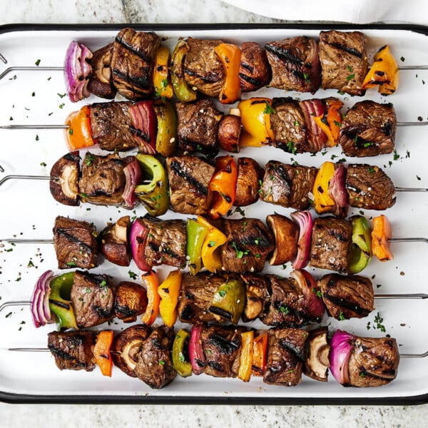 A white tray of beef shish kabobs