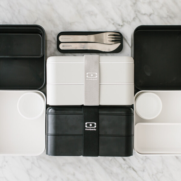 Black and white bento box containers on a countertop.