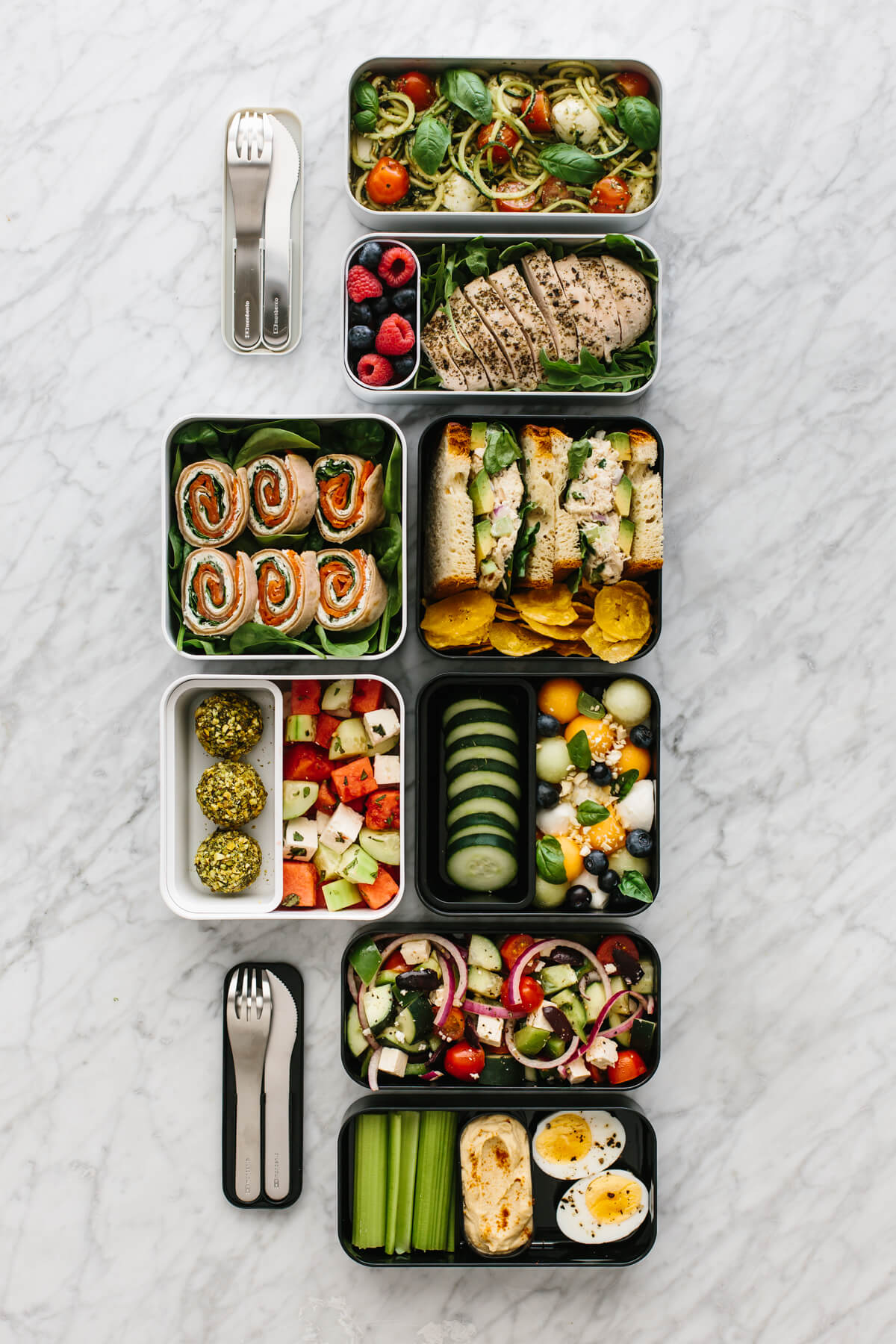 Several bento box lunches arranged next to each other on a countertop.