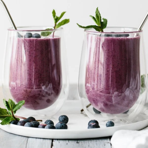 Two blueberry smoothies in glasses.