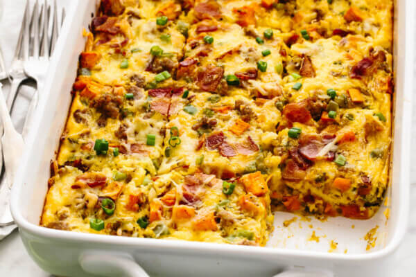 An easy breakfast casserole with sausage in a white pan next to forks.