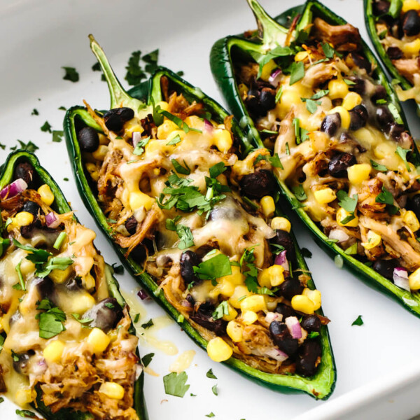 A baking dish of carnitas stuffed poblano peppers lined up