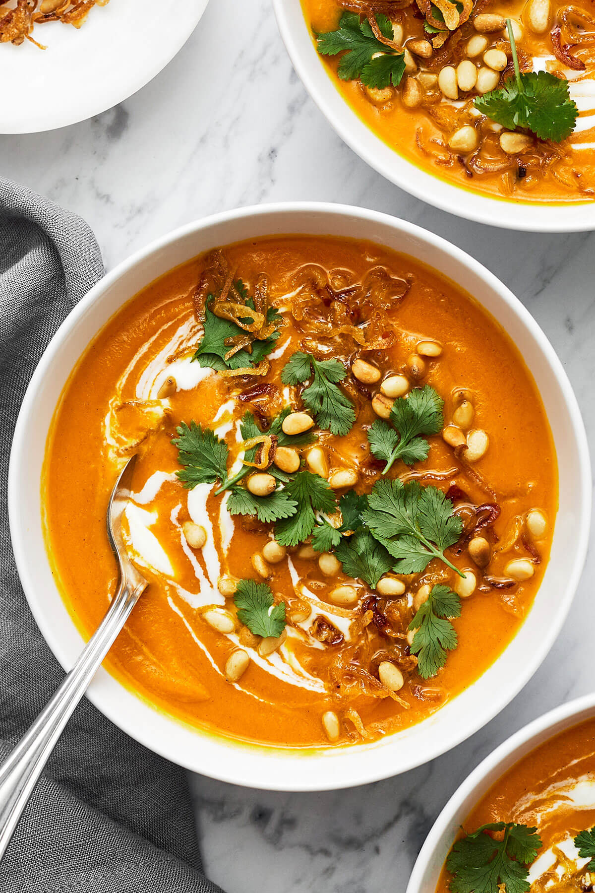 Carrot ginger soup in a bowl with a spoon