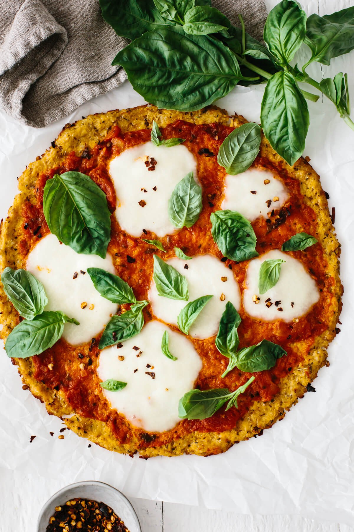 Cauliflower pizza crust topped with marinara, mozzarella and basil.