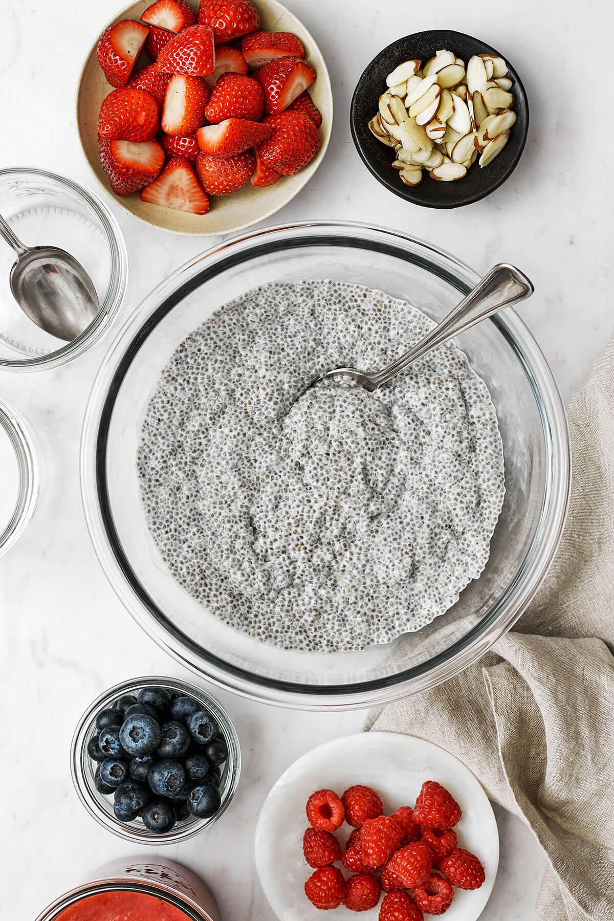 Assembling chia pudding with bowls of ingredients