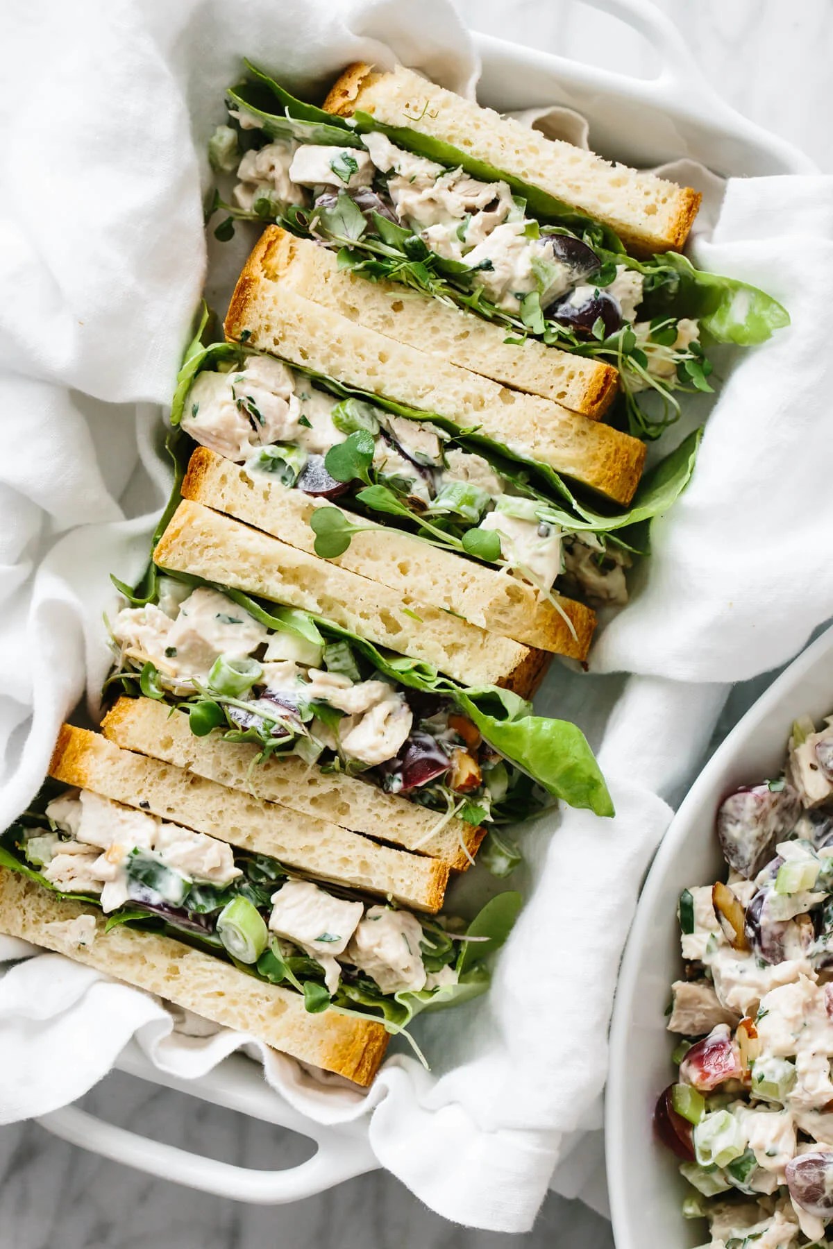 Chicken salad sandwiches sliced in half on a serving tray.