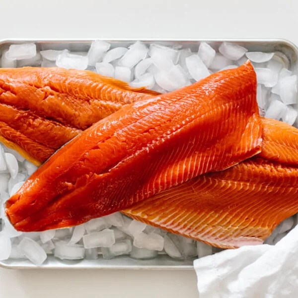 Raw salmon filets on a tray of ice.