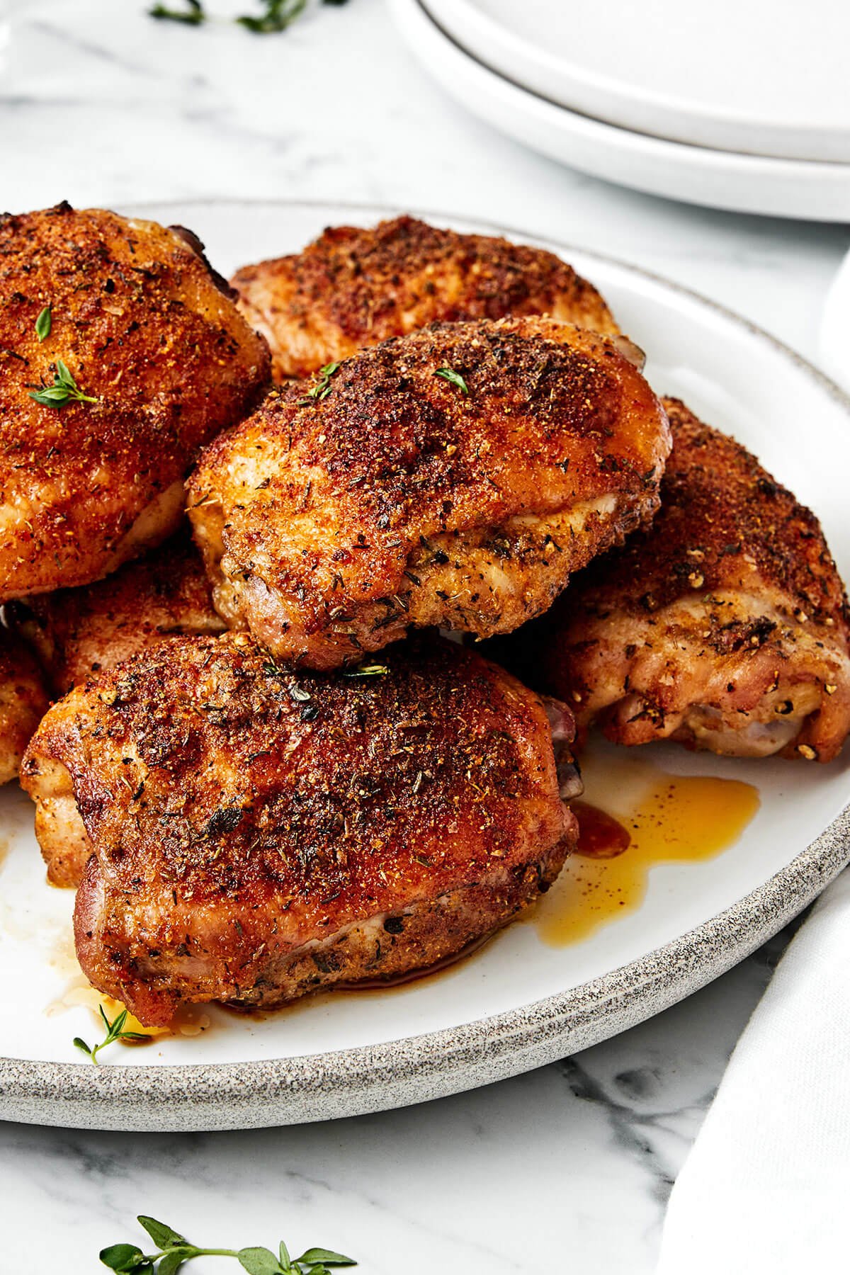 Crispy baked chicken thighs on a plate.