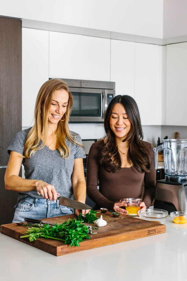 Lisa Bryan and Emily Liao in the kitchen testing recipes for Downshiftology