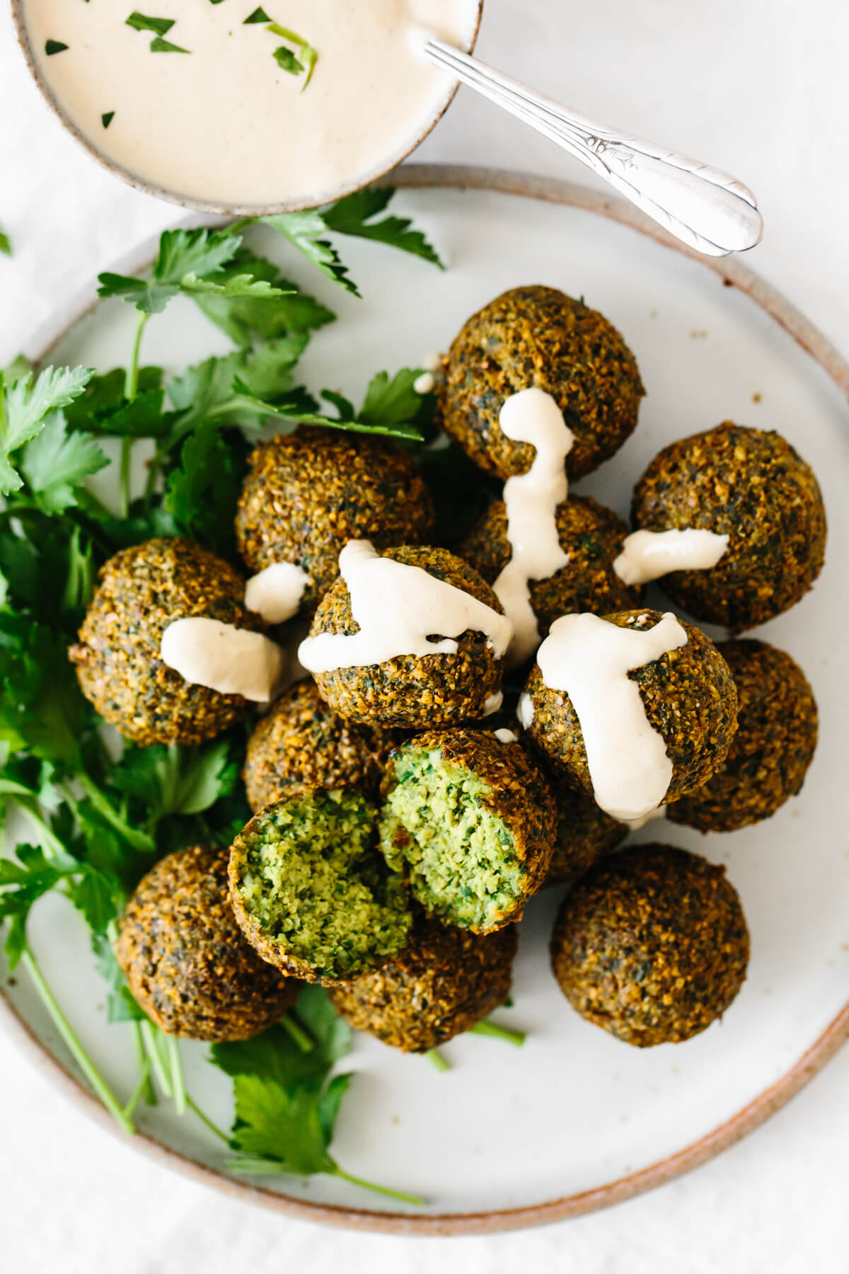 Falafel on a plate with tahini sauce.