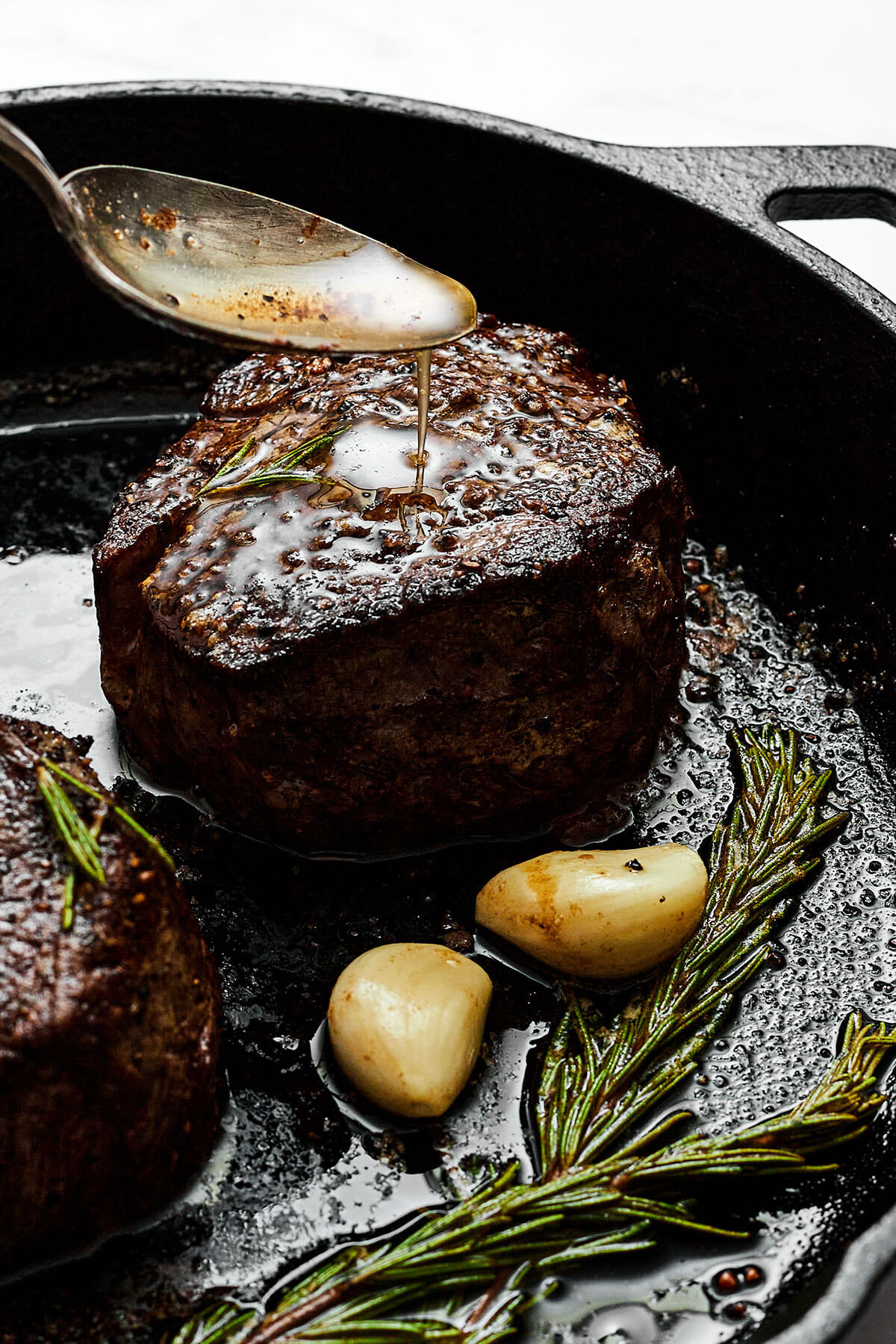 Spooning butter sauce over filet mignon