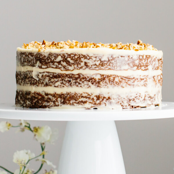 Gluten-free carrot cake on a cake stand with frosting.
