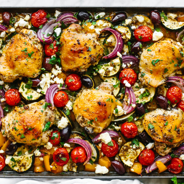 A sheet pan of chicken thighs and Mediterranean vegetables.