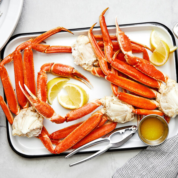 A tray of cooked crab legs and lemons