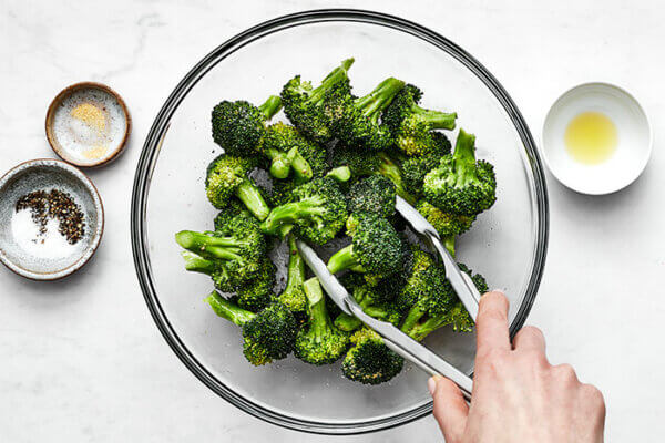 Mixing seasoning with air fryer broccoli