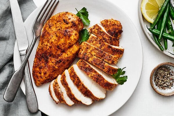 Air fryer chicken breasts sliced on a plate