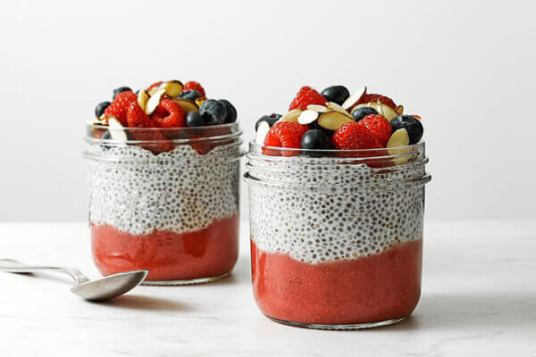 Glass jars of chia pudding with a spoon