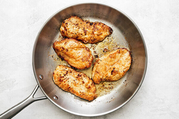 Cooking chicken breasts in a pan for chicken piccata
