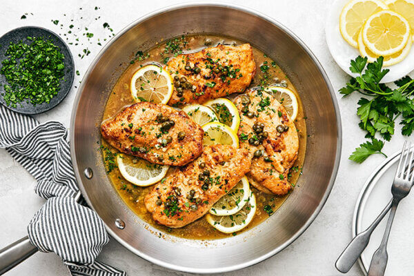 A pan with cooked chicken piccata