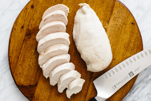 Poached chicken on a cutting board.