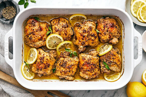 A baking dish filled with Greek lemon chicken thighs