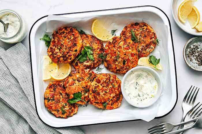Salmon patties in a white dish with sauce.