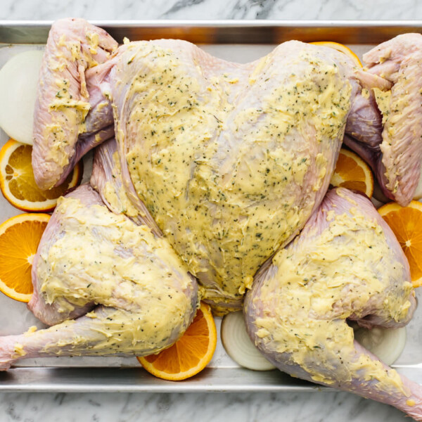 A spatchcock turkey flat on a baking tray, ready to be cooked.