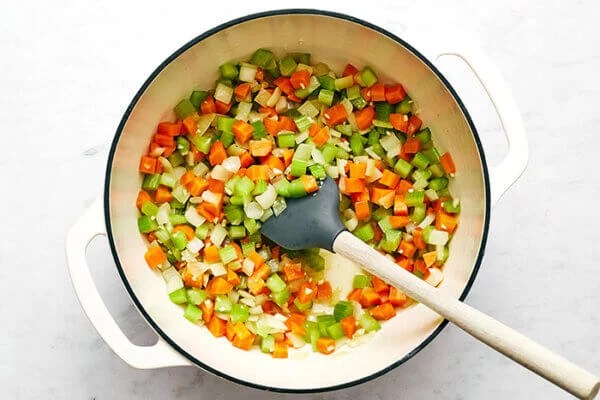 Cooking veggies in a white pot for split pea soup
