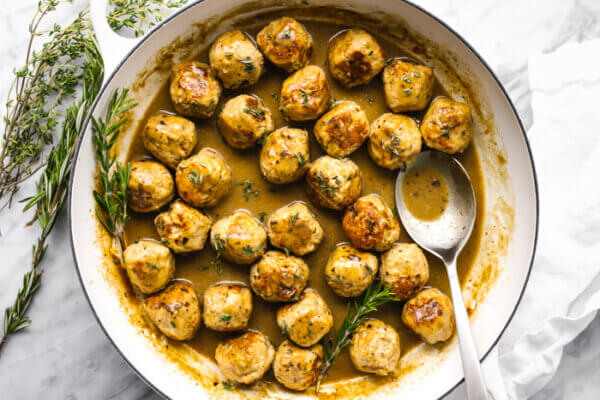 A large pan filled with turkey meatballs in a maple mustard sauce