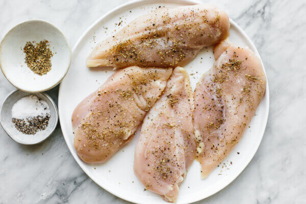 A plate of seasoned chicken for tuscan chicken