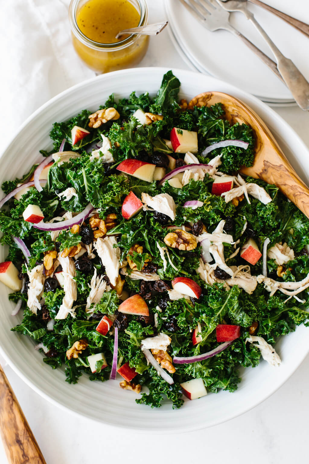 Kale salad with chicken and apples on a white table