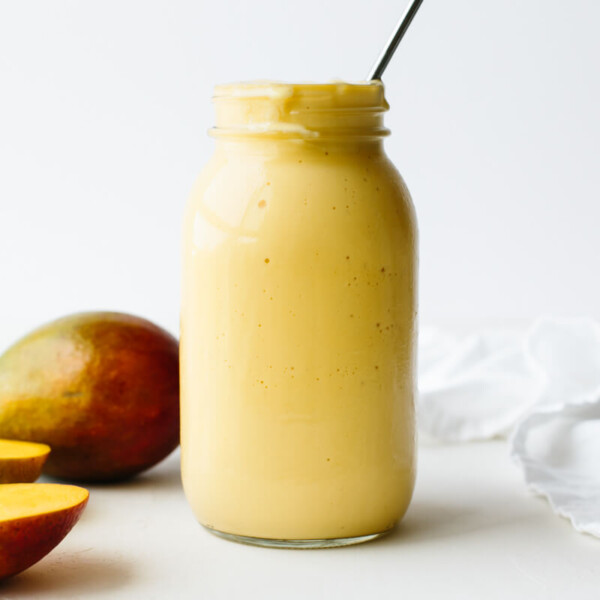 A mango smoothie next to mangos