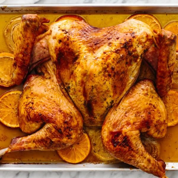 A sheet pan with a maple orange glazed spatchcock turkey.