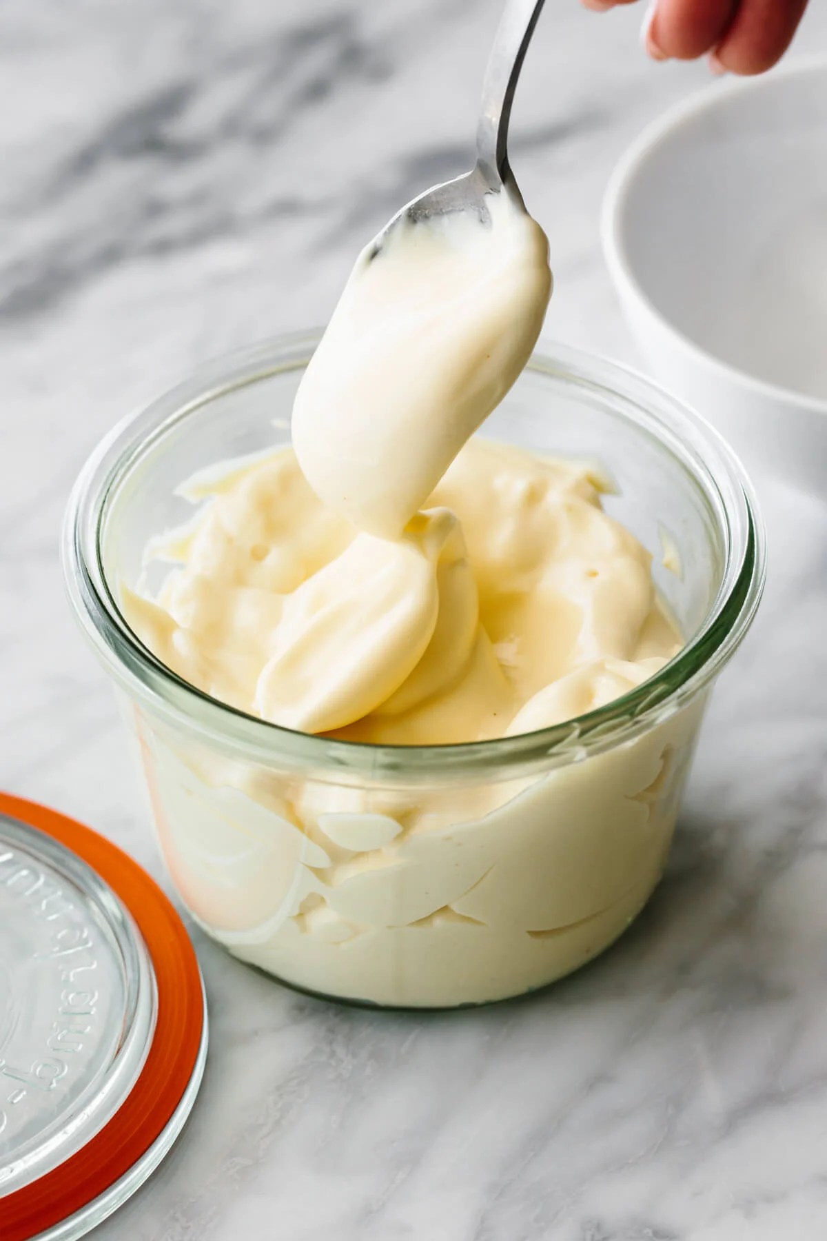 Mayonnaise in a glass storage container.