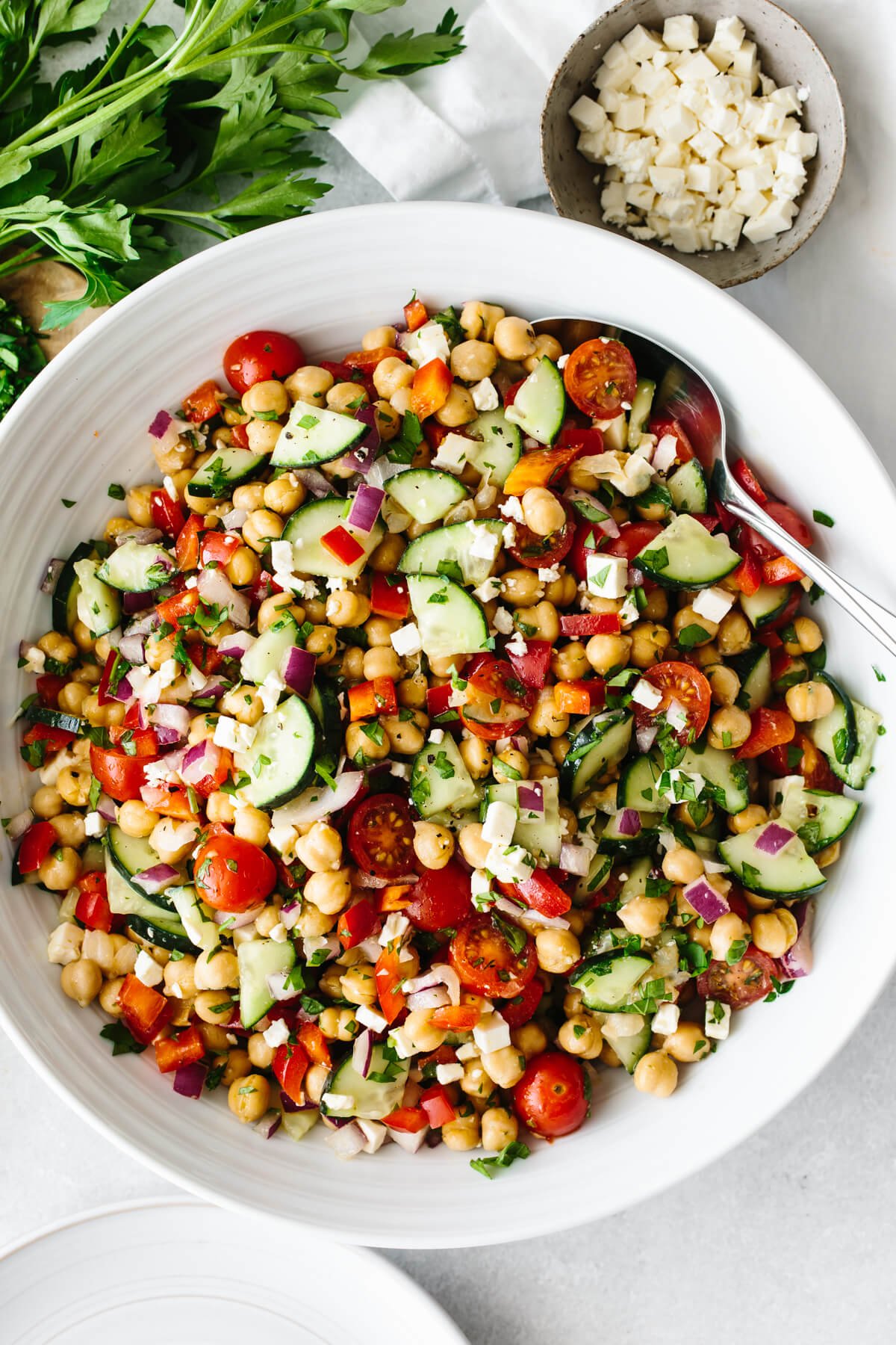 Mediterranean chickpea salad in a large white bowl on a table.