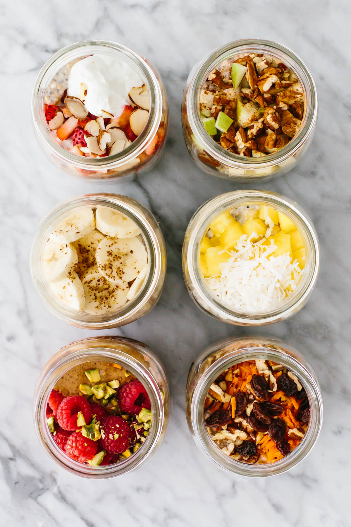 Overnight oats with different flavors in jars on a table.