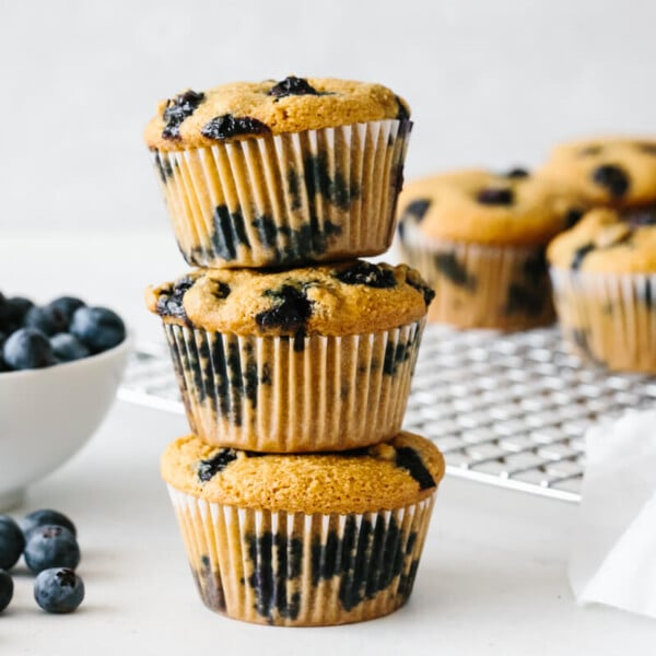 Paleo blueberry muffins stacked on top of each other.