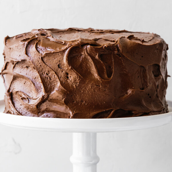Paleo chocolate cake on a white cake stand.