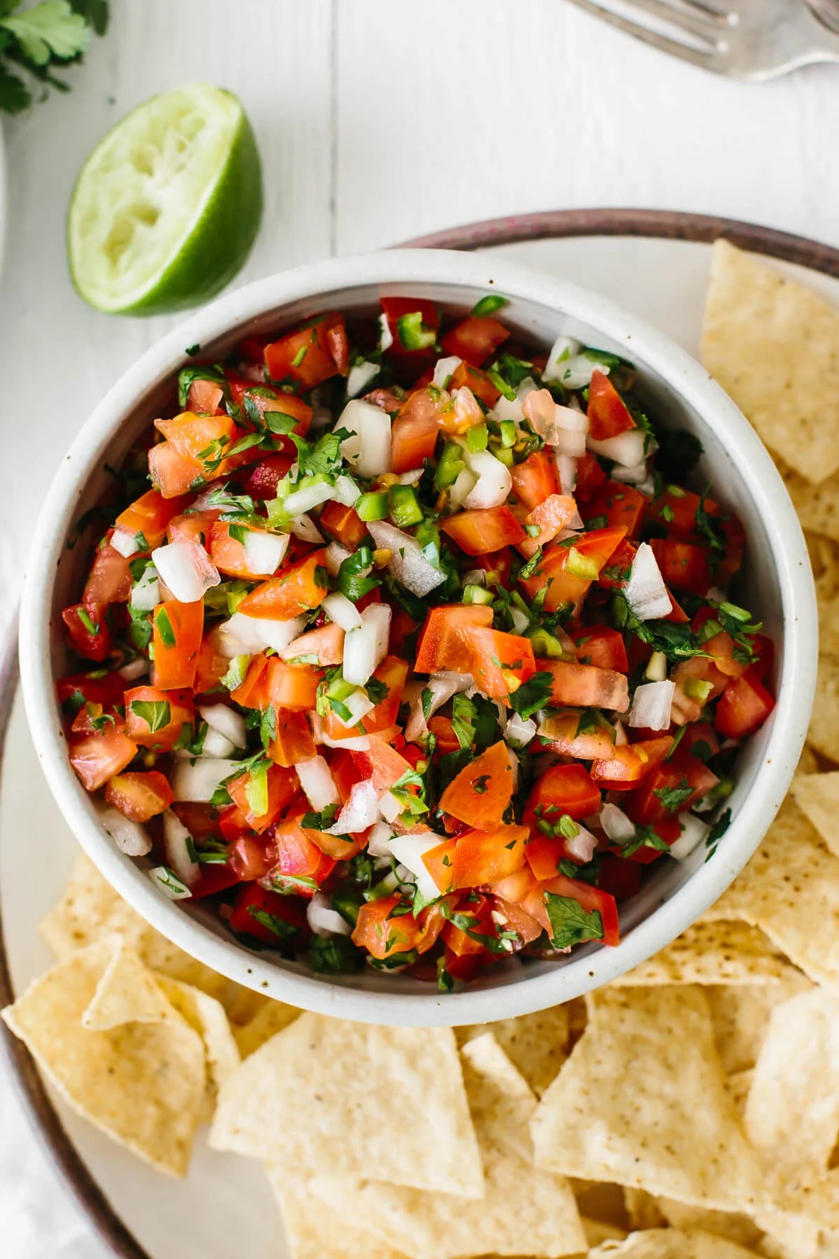 Pico de gallo in a bowl next to chips.