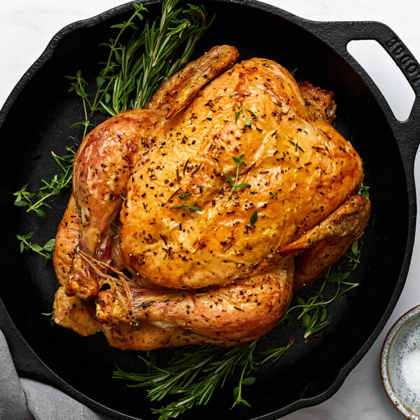 A skillet with roast chicken and herbs