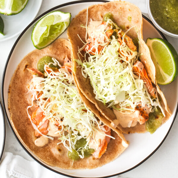 Two salmon tacos on a plate.