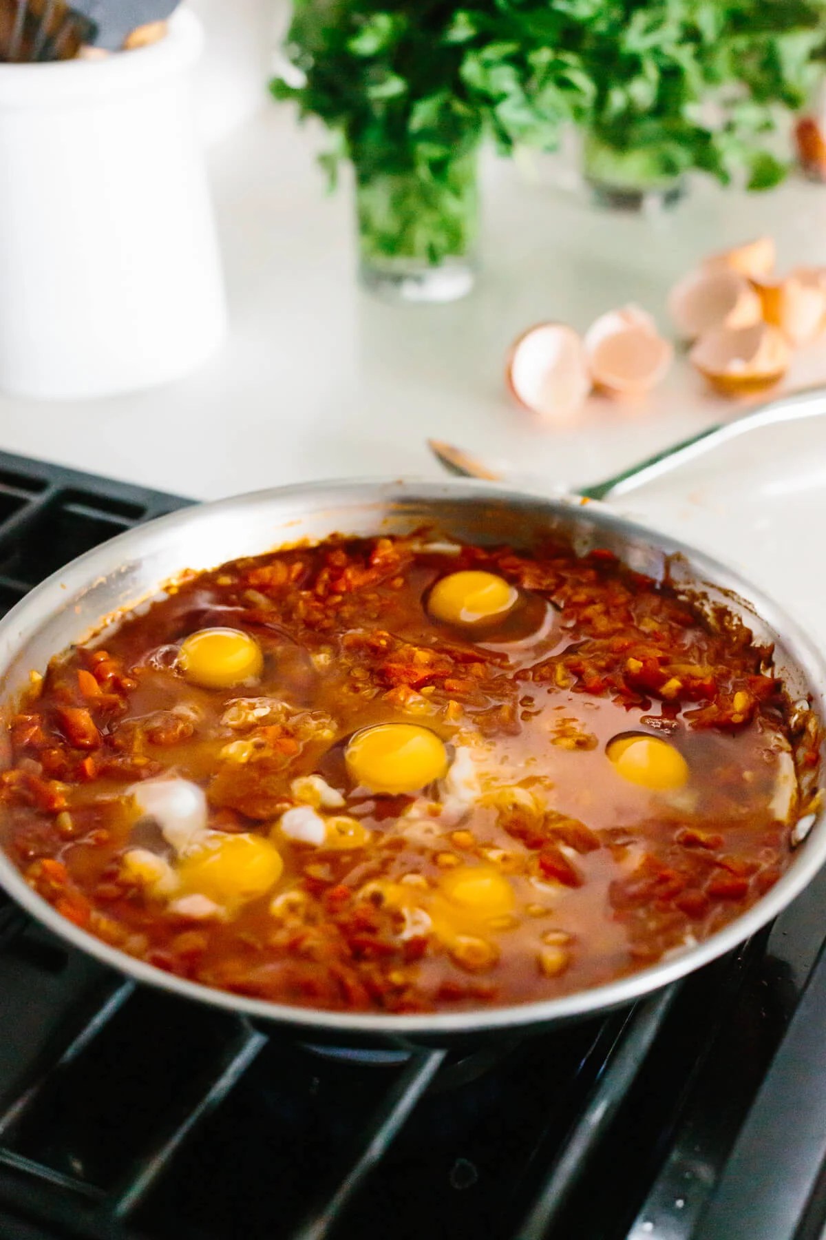 Eggs poaching in spiced tomato mixture.