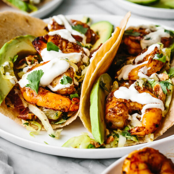 Two shrimp tacos on a plate with cilantro lime slaw.