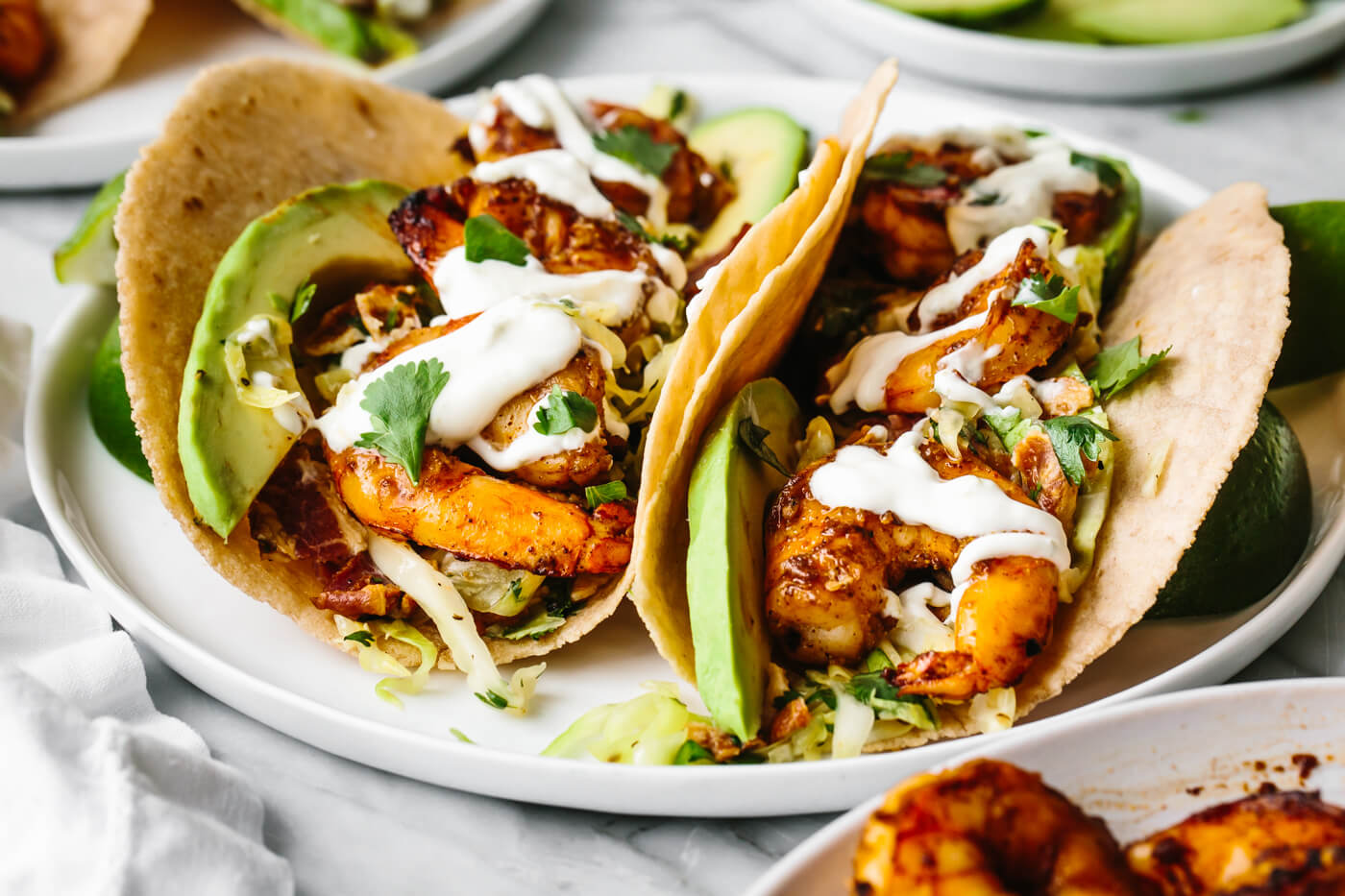 Two shrimp tacos on a plate with cilantro lime slaw.
